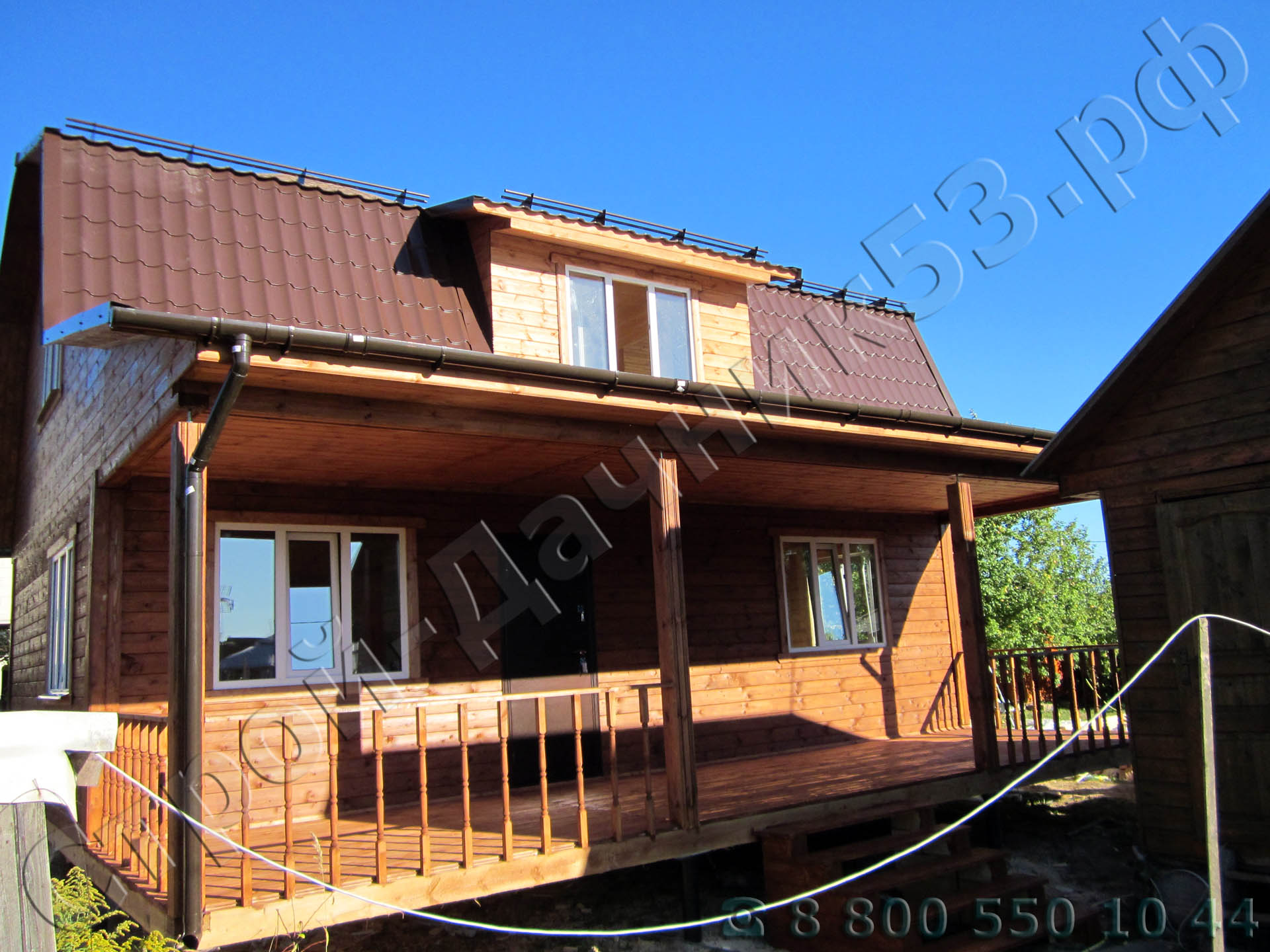 Вид дома с входа на террасу установленной кукушки в крыши для дополнительного света на втором этаже