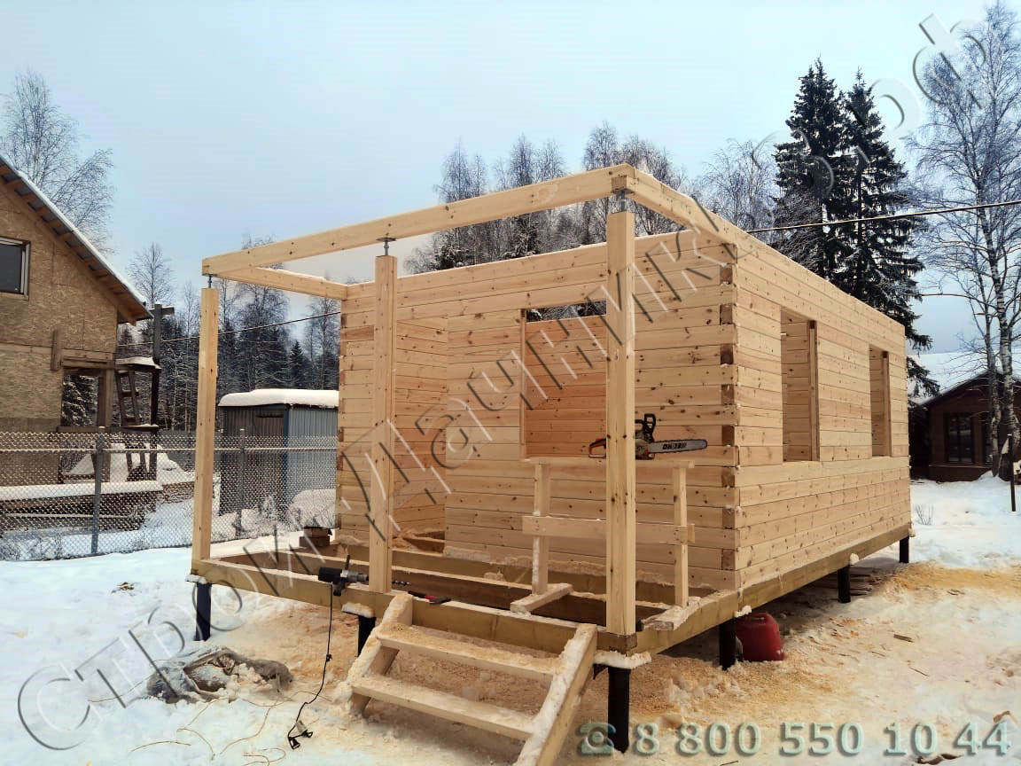 Сруб с выведенной открытой террасой на усадочных домкратах и с установленными ройками в дверных и оконных проемах для фик